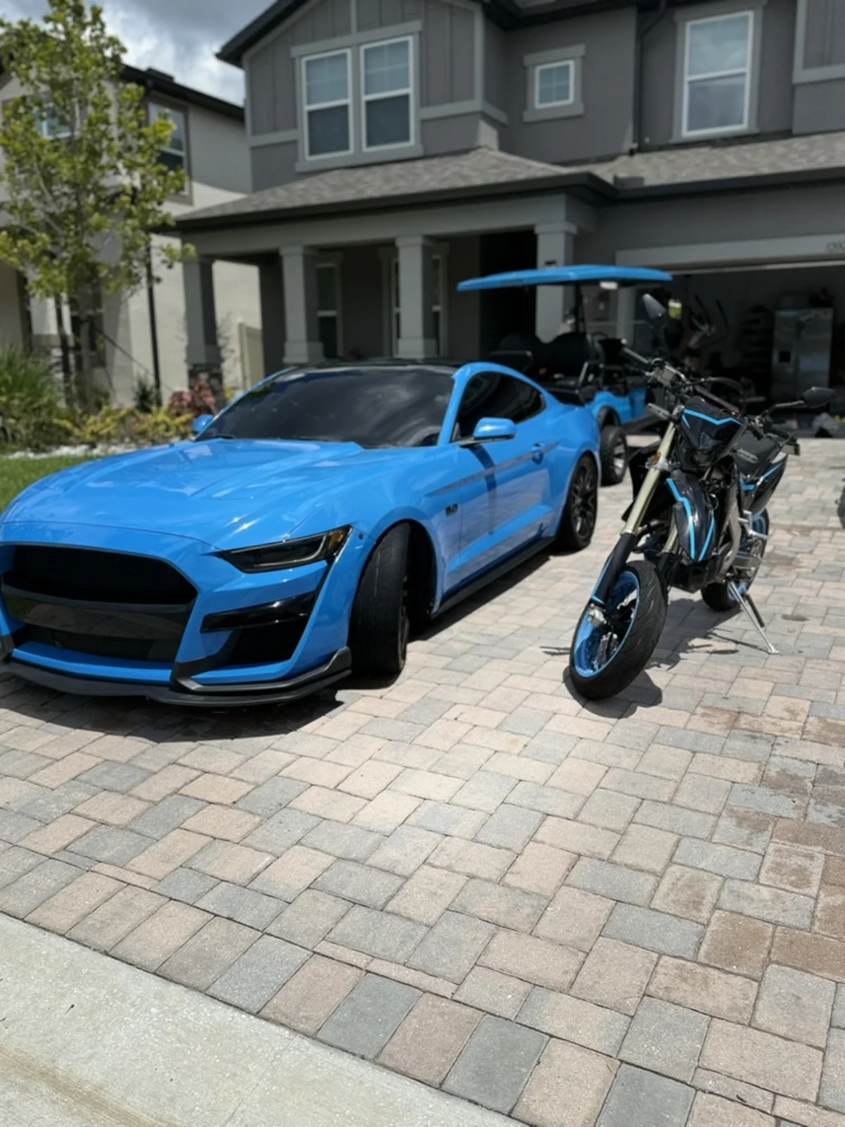 Blue Ford Mustang and blue motorcycle displayed together after detailing