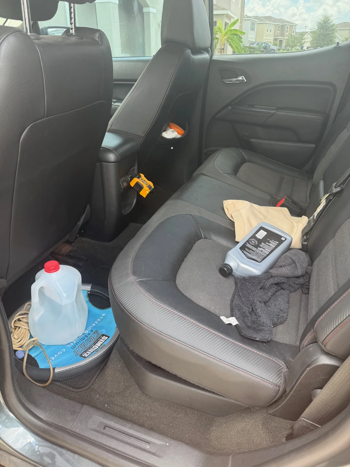 GMC pickup rear seating before detailing, cluttered with loose items