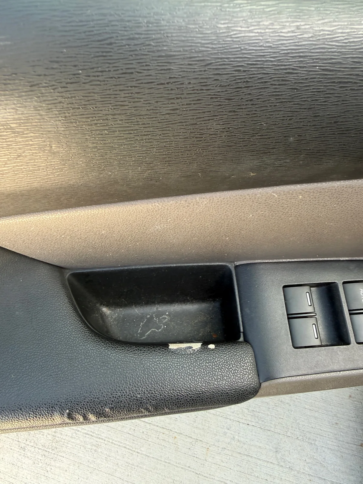 Honda Odyssey driver door before detailing, with dust and debris around the controls