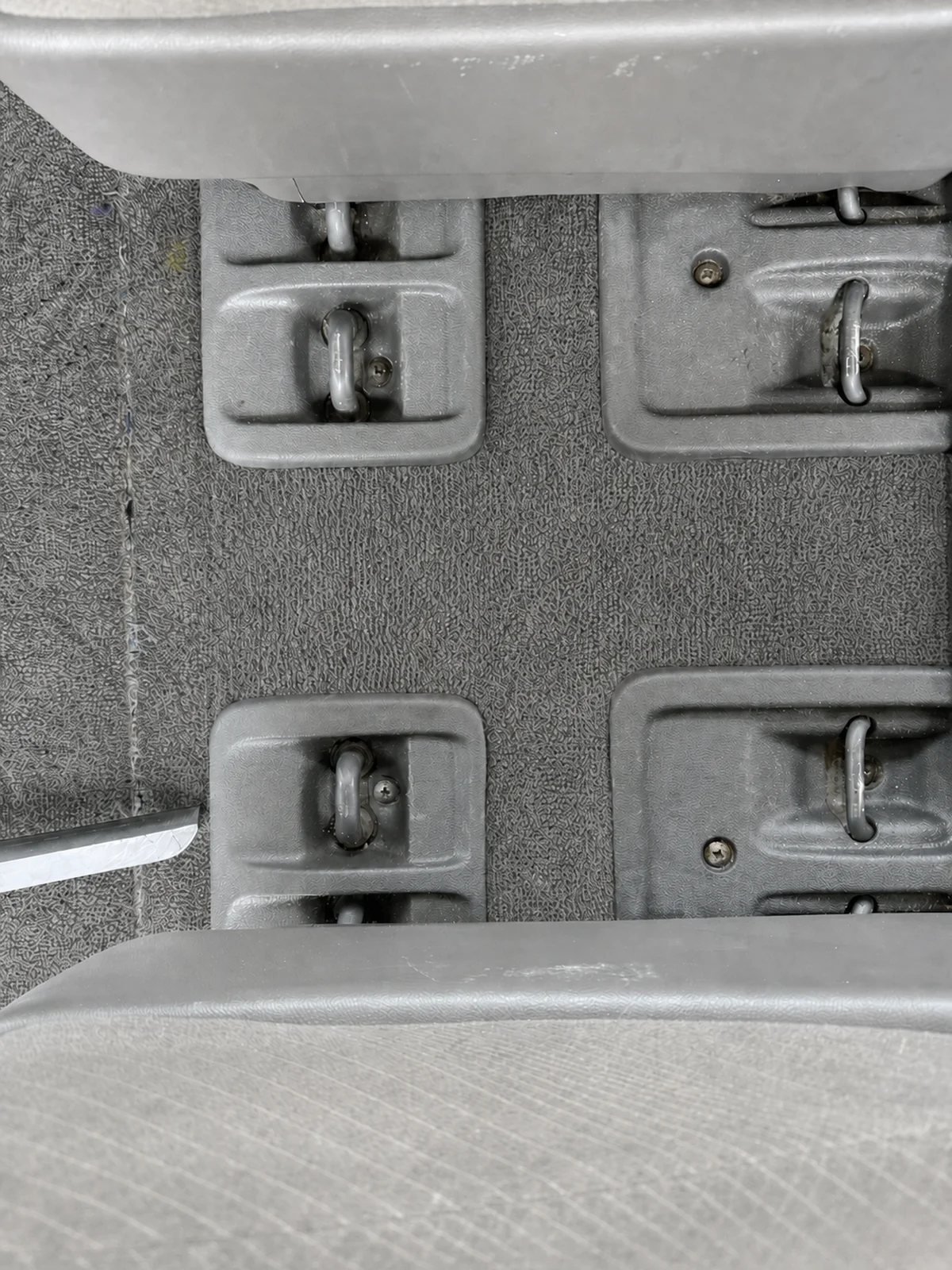 Honda Odyssey carpet and seat-mount tracks after detailing, clean with restored medium-gray carpet