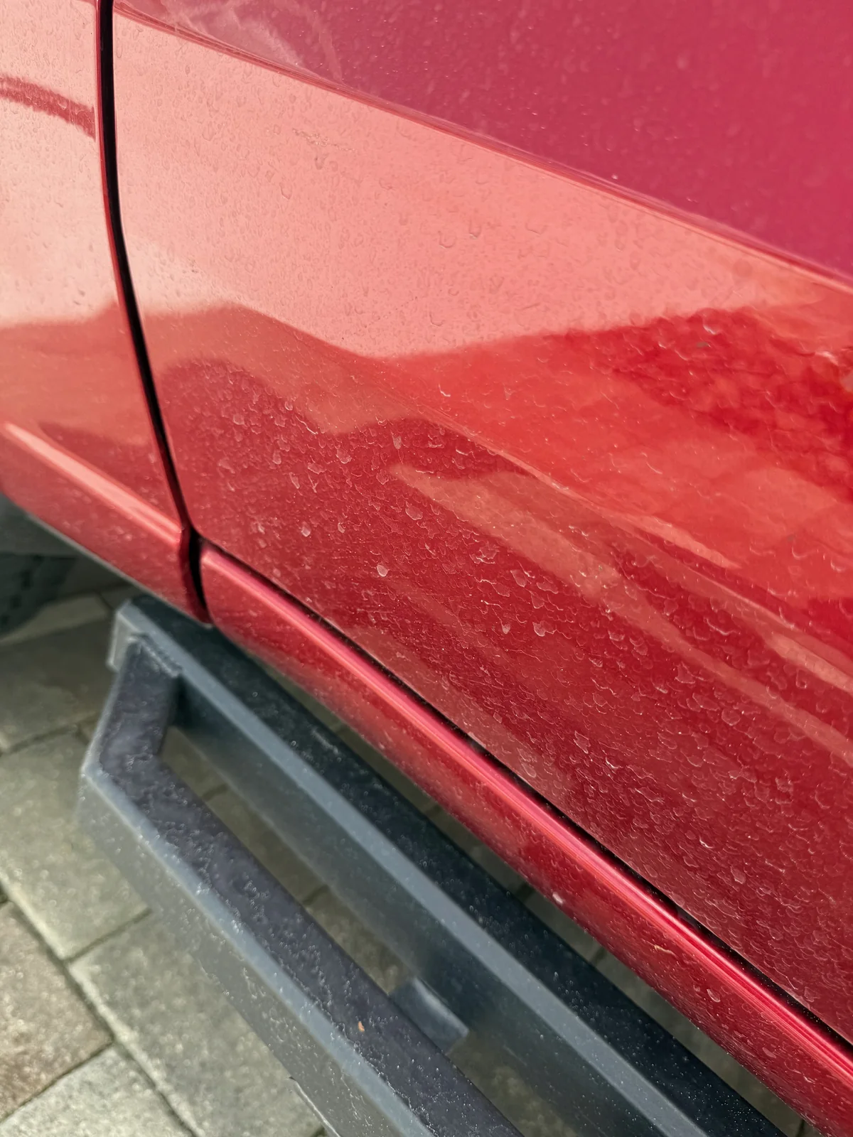 Red Chevrolet pickup exterior before detailing, covered in dust and road film