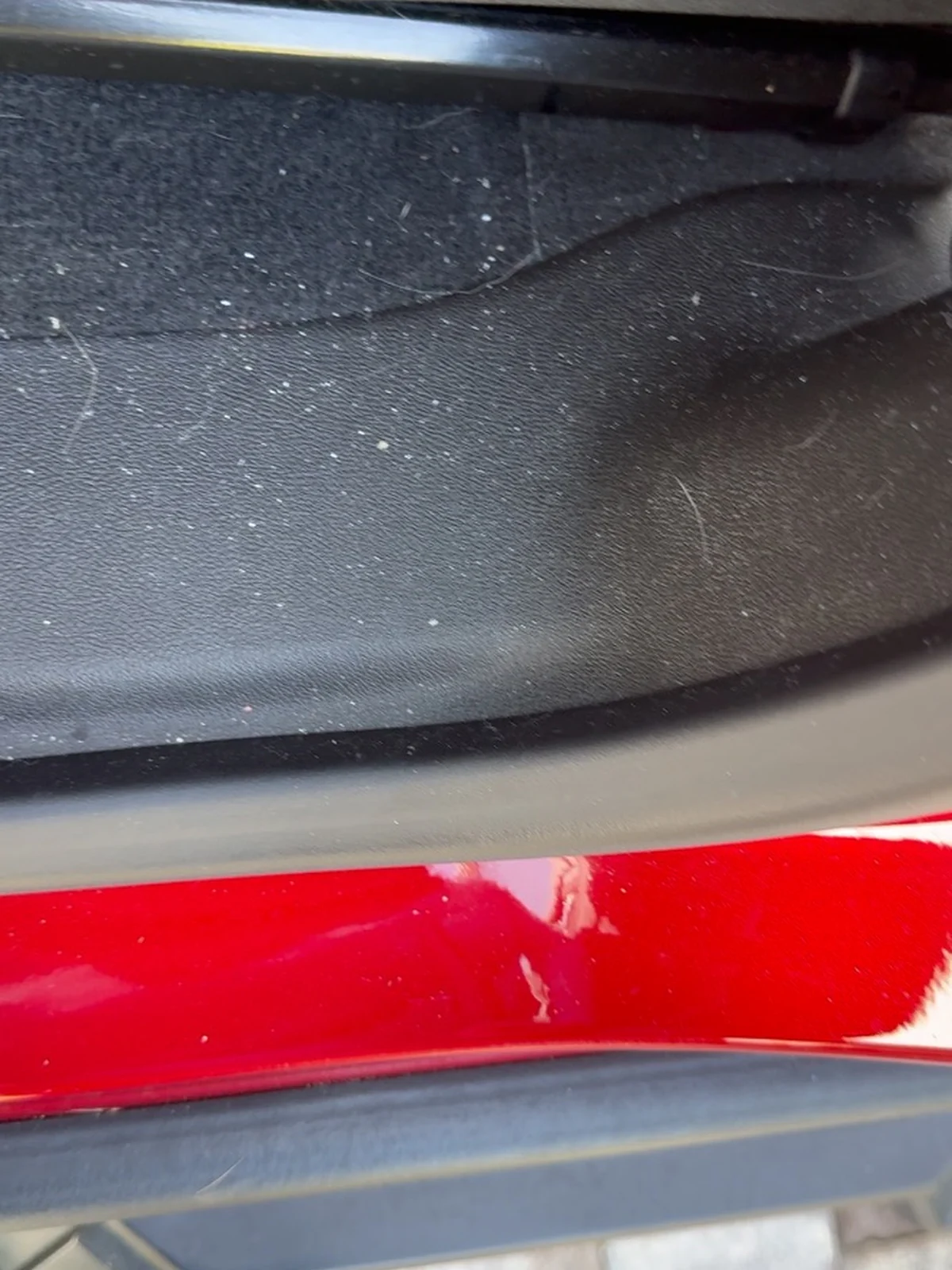 Red Chevrolet pickup driver entry before detailing, with dust and debris along the sill and floor